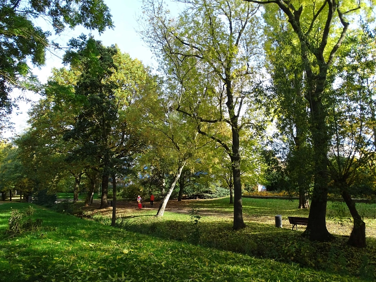 Blühende und grüne Bäume säumen den Park mit zwei Spaziergängern. © Lutherstadt Wittenberg